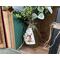 A mason jar flower arrangement sits next to old books. The jar is decorated with a natural birch bark tag. The tag has a bunny drawn on it.
